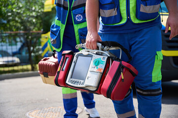 Close up of paramedic ready with AED outside ambulance