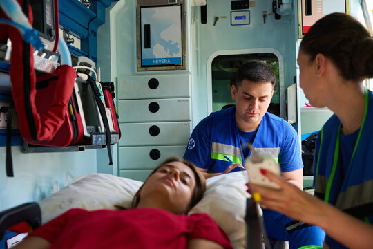 Professional paramedics assisting female patient during critical situation