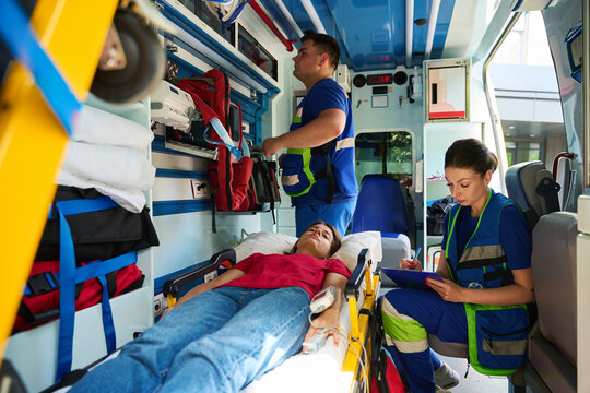 Healthcare professionals at work treating woman in ambulance