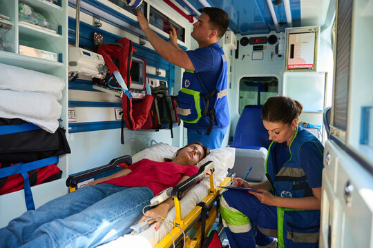 Female patient receiving emergency care from paramedics in ambulance