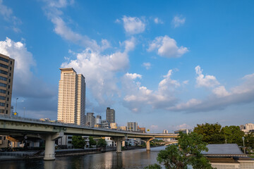 Fototapeta premium 夕焼け雲と川をまたぐ高速道路とタワーマンション
