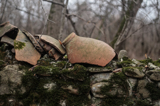 Broken Clay Pots On Mossy Stone Wall