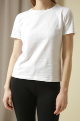 Female model in basic white cotton t shirt and 3/4 cropped black leggings.