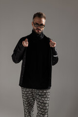 Elegant man holding leather jacket with both hands