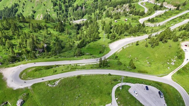 Passo Giau, Giau pass Italy, dolomites. Drone flight, view on road on mountain pass below. Some cars are driving on the widing road in the Italian Dolomites. Alpine meadows. Wild nature. Sunny summer 