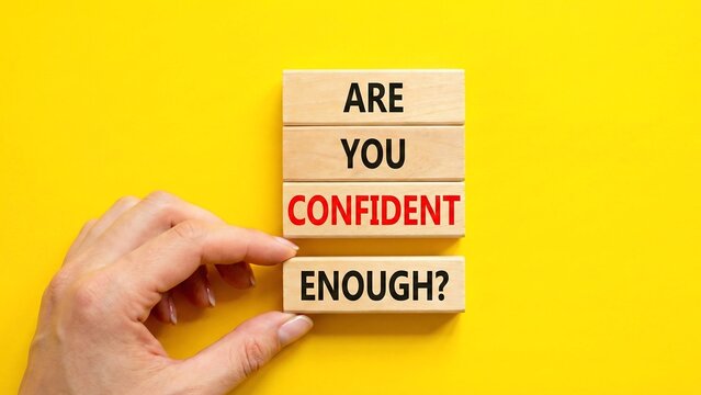 Confidence symbol. Concept words Are you confident enough wooden blocks. Beautiful bright yellow background. Businessman hand. Business and Are you confident enough concept. new