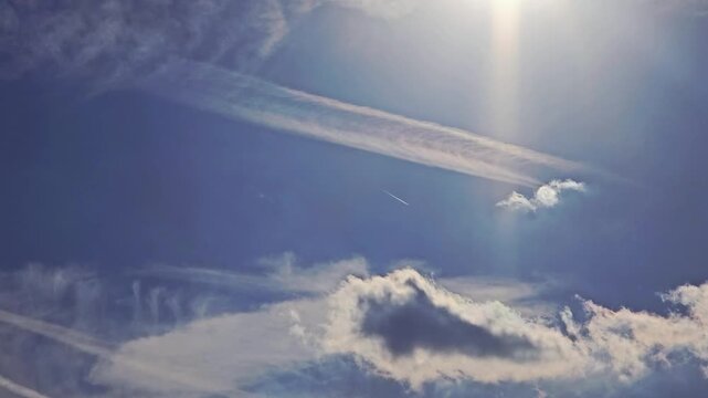 Commercial Jet Airplane Cruising at High Altitude in a Big Blue Sky With Clouds Making Contrails and Patterns in the Atmosphere, Airways, Air Travel, Sun Flair, No Audio, 19:6, Still Shot, 60fps - 4