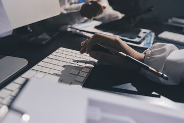 Two doctors and a female nurse meet at a table in the hospital, collaborating on medical tasks using laptops and computers