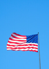 Photo of American Flag flying on blue Skye background