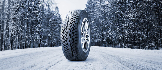 Winter tire on road covered with snow in snowfall