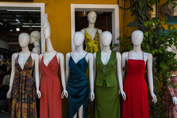 Mannequins modeling elegant formal clothing outdoors.