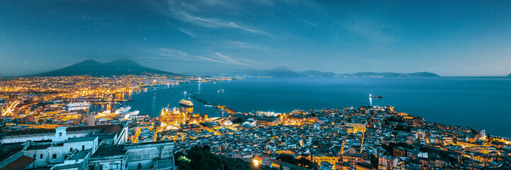 Naklejka premium Naples, Italy. Skyline Cityscape In Evening Lighting. Tyrrhenian Sea And Landscape With Volcano Mount Vesuvius. City In Night Illuminations