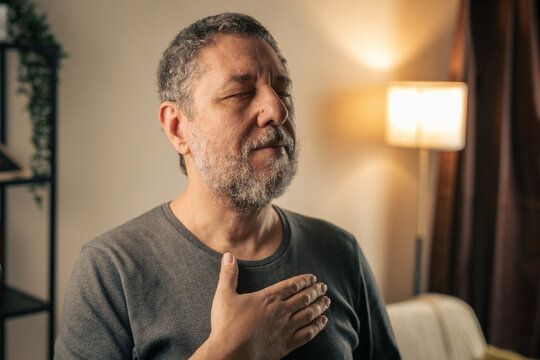 Mature man practicing mindful breathing at home in calm reflective moment