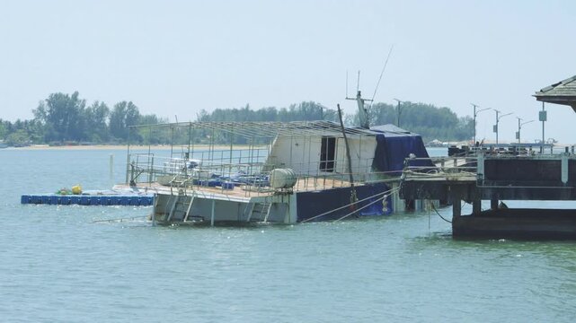 A ship or boat that sank near the pier apparently suffered a hole or leak at the pier pier on Koh Kho Khao Island. High quality 4k footage