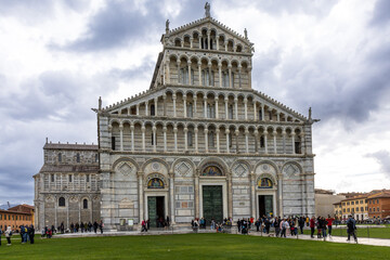 Fototapeta premium Pisa Cathedral, a magnificent example of Pisan Romanesque architecture, stands in the Piazza dei Miracoli (Square of Miracles). Its white marble facade features arches and columns. Tuscany, Italy