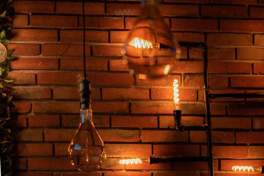 Bulbs illuminating caf&eacute; with bricks wall.