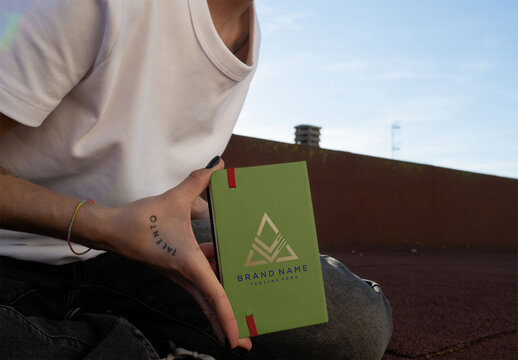 Mockup of real photo from Woman Showing a Back cover Book on a Rooftop