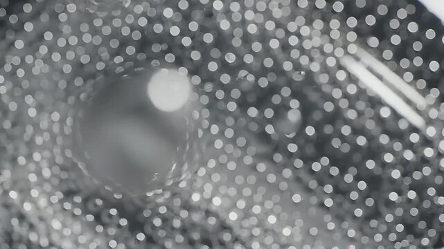 Close-up of a metallic surface with a circular pattern and reflective dots.