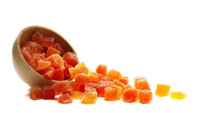 Heap dried papaya cubes with sugar, candied fruit in bamboo bowl isolated on white background, side view