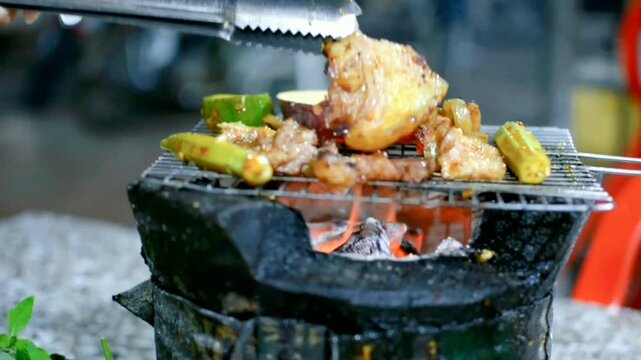 Traditional charcoal grilling of meat and vegetables on clay stove