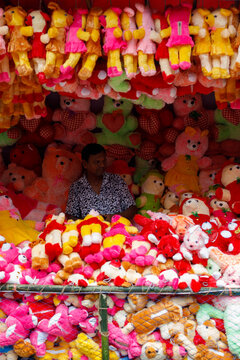 Dhamrai, Bangladesh - 01 July 2022: View of a vendor amidst a vibrant sea of plush toys, a colorful spectacle at the Sri Sri Yasho Madhav Temple.