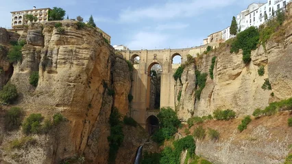 Ingelijste posters Ronda Puente Nuevo Ronda Bridge and Cliff: The iconic Puente Nuevo bridge, a testament to architectural marvel, spans a breathtaking gorge in Ronda, Spain, surrounded by rugged cliffs and lush vegetation.  © Felipe