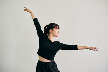 Young Japanese woman performing jazz dance with expressive arm movement