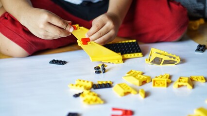 Close up of child's hands playing with colorful plastic bricks or lego. Toddler having fun and building out of bright constructor bricks. Development toys © Hai.. Zainul