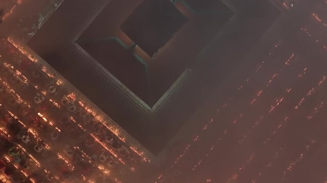 Aerial view of a building surrounded by burning lights creating a hazy and warm glow, Dhaka, Dhaka Division, Bangladesh.