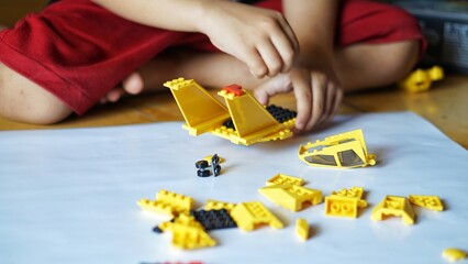 Close up of child's hands playing with colorful plastic bricks or lego. Toddler having fun and building out of bright constructor bricks. Development toys © Hai.. Zainul