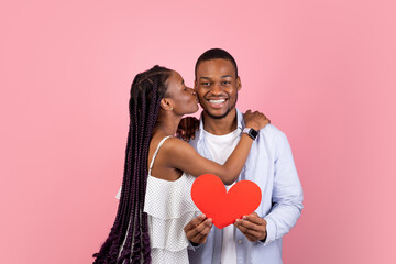 St. Valentines Day Concept. Portrait of African American couple in love holding red paper heart...