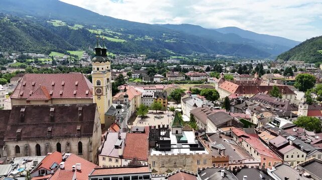 Forward drone flight, bird view, Brixen, Bressanone city. View on the grand place with the cathedral and St. Michael church. sunny summer view. Photo for tourist brochure, publicity. City in south Tyr