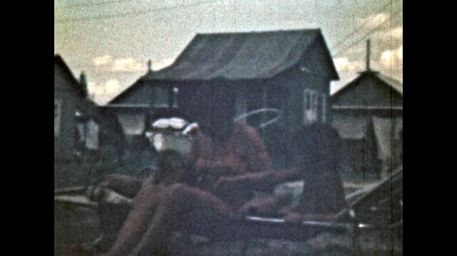 Mother, children relax on folding cot in summer holidays. Happy family enjoying outdoor leisure, sunbathing in rural countryside nature on vacation. Old film. Archival retro 1970s. Vintage archive