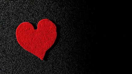 Obraz premium devotion. Minimalist red heart on a textured black surface, symbolizing love and gratitude. wellbeing guides, coaching materials, designed for mental health education and mindfulness programs. 