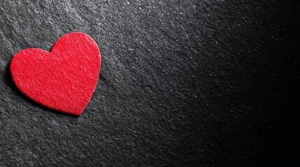 Obraz premium devotion. Minimalist red heart on a textured black surface, symbolizing love and gratitude. wellbeing guides, coaching materials, designed for mental health education and mindfulness programs. 