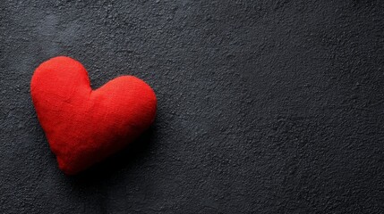 Obraz premium devotion. Minimalist red heart on a textured black surface, symbolizing love and gratitude. wellbeing guides, coaching materials, designed for mental health education and mindfulness programs. 
