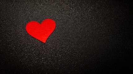 Obraz premium devotion. Minimalist red heart on a textured black surface, symbolizing love and gratitude. wellbeing guides, coaching materials, designed for mental health education and mindfulness programs. 