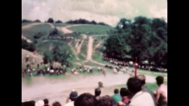 Wide view, numerous sidecar motocross teams racing at high speed in off-road dirt track during competition. Motorcycles move dynamically. Extreme motorsport action. Old retro film. Vintage archive