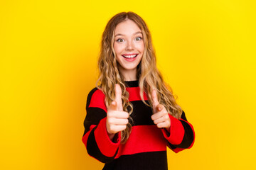 Cheerful young woman in stylish casual striped sweater posing with a bright happy smile against a...