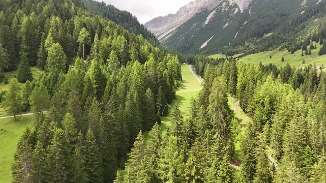 22 july 2024, Imst, Austria. Backward drone flightn reveal at ski slope in summer, beautiful fresh green meadows, pristine alpine pine forest trees during summer day. Hiking trail. Outdoors, nature, e