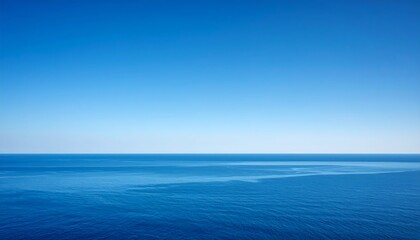 Obraz premium A serene vista showcases a vast, seamless expanse of the open ocean under a clear, gradient sky, a perfect display of nature's beauty