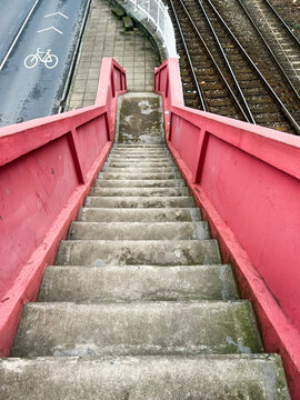 Urban pedestrian bridge stairs descending to transportation infrastructure