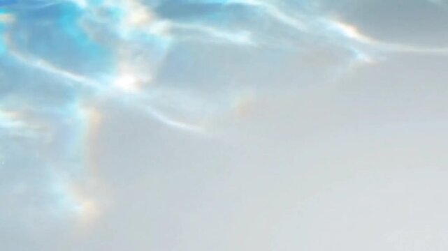 Cinematic close-up of sunlight reflecting on blue water creating abstract caustic patterns