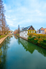 Fototapeta premium Strasbourg, France - December 5, 2025: Beautiful travel landscape with half-timbered houses on the banks of the river ill and decorated flowers in Strasbourg. France quarter in Strasbourg.