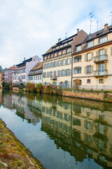 Fototapeta premium Strasbourg, France - December 5, 2025: Beautiful travel landscape with half-timbered houses on the banks of the river ill and decorated flowers in Strasbourg. France quarter in Strasbourg.