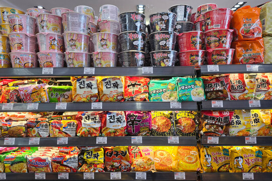 Penang, Malaysia: Nov 02, 2025: Extensive retail display of packaged ramen and instant noodles including Shin Ramyun, Samyang Buldak, and Jin Ramen in a brightly lit supermarket aisle.