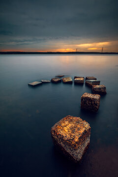 Row of weathered concrete blocks in the sea at sunset, Curonian Gulf, Lithuania