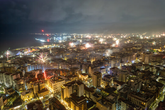 Aerial nighttime cityscape with fireworks exploding at new year, Catania, Sicily, Italy