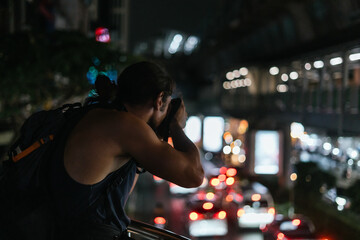 Photographer capturing urban city nightlife and bokeh lights