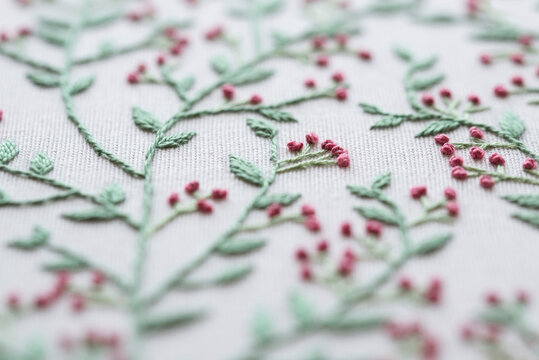 Full frame close-up of piece of linen fabric embroidered with a floral motif